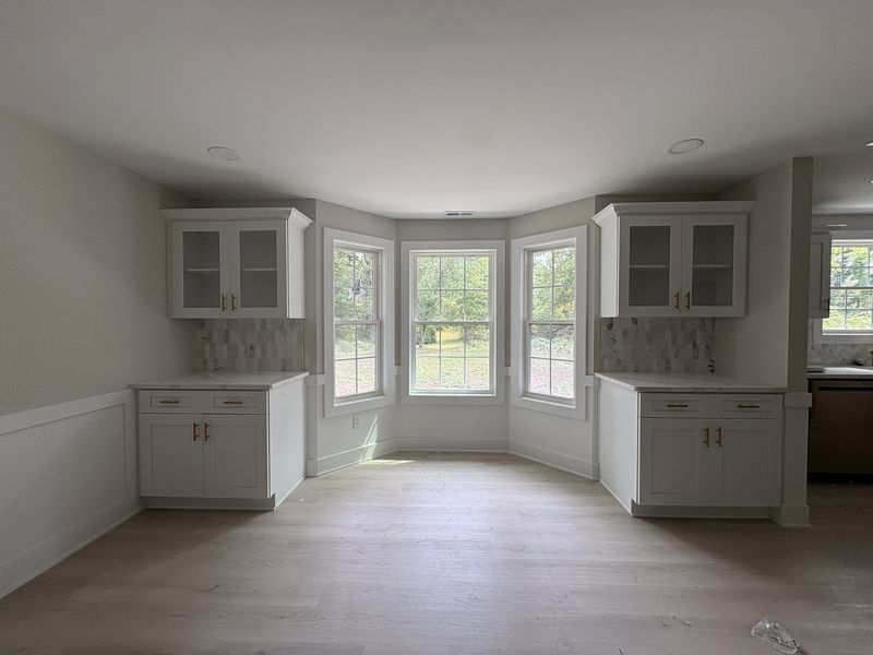 Matching built-in cabinets either side of a bay window, with wainscot panelling below the sills
