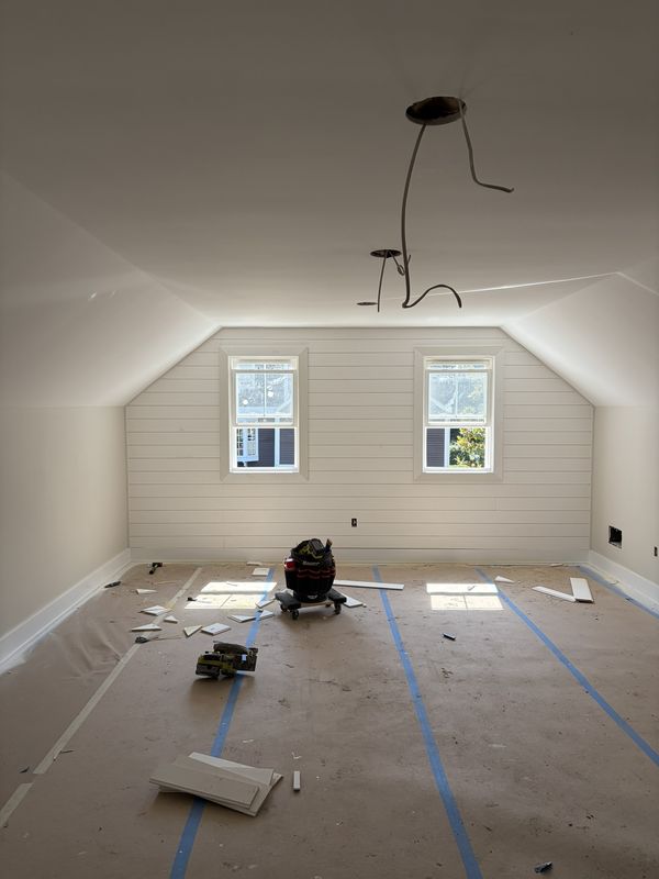 Bonus room with a vaulted ceiling and shiplap-clad walls, taped and ready for flooring