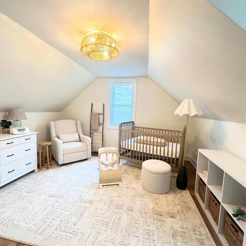 Finished attic conversion with vaulted ceilings, a woven flush-mount light and a neutral palette