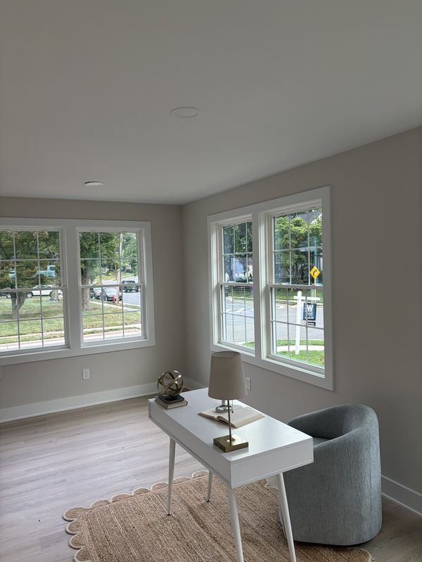 Sitting room with newly cased windows on two walls and continuous baseboard, furnished and finished